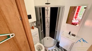 Ein Badezimmer mit Duschkabine, Toilette und Waschbecken.