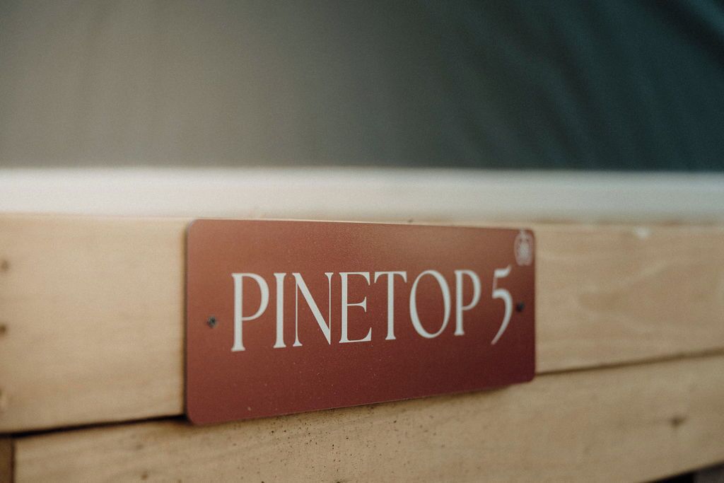 A wooden bed frame with a label that reads "PINETOP 5".