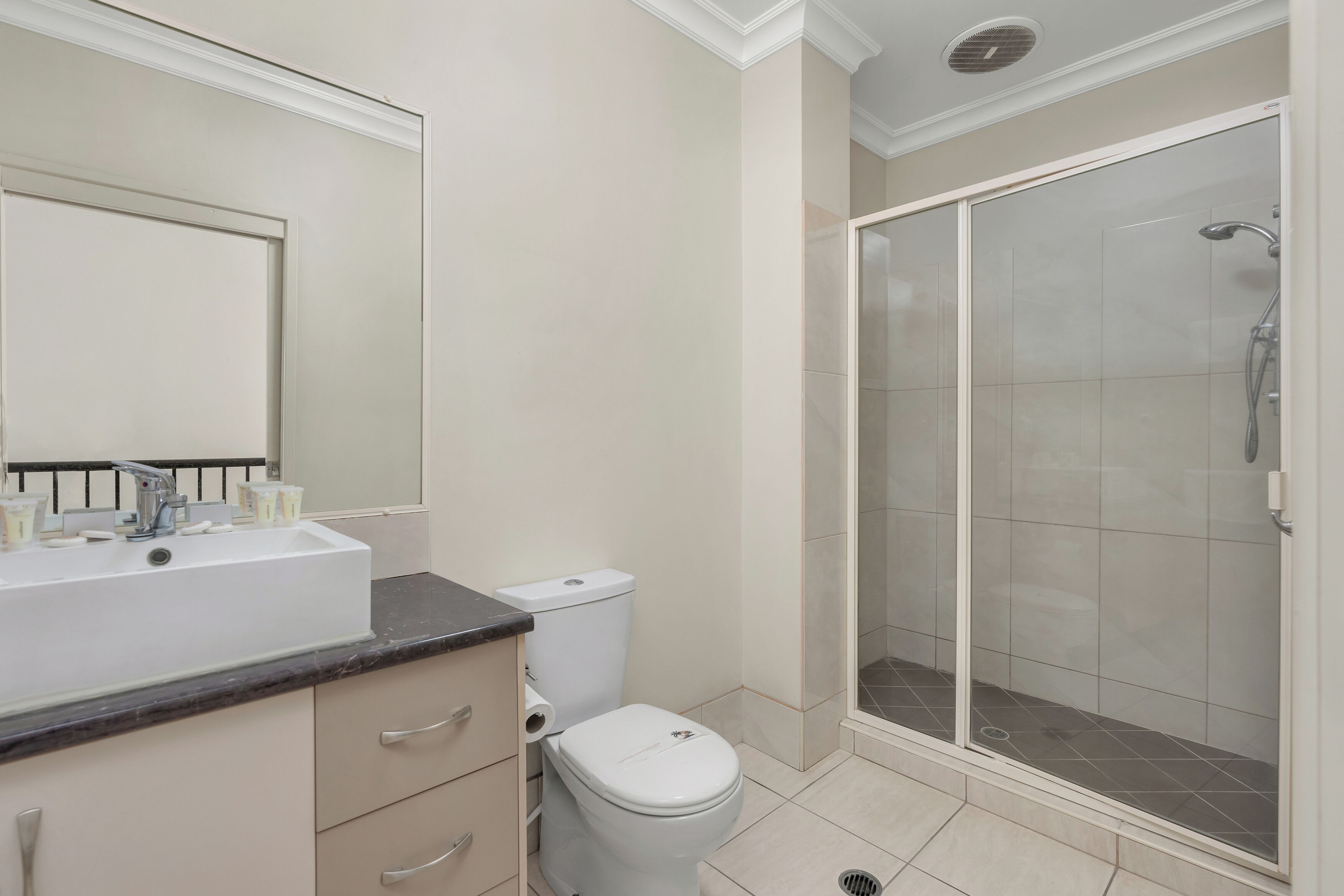 A bathroom with a sink, toilet, and glass-enclosed shower.