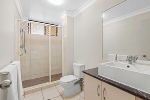 A bathroom with a shower, toilet, and sink.