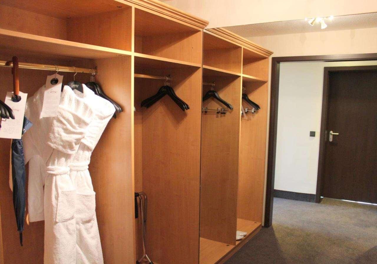 A walk-in closet with multiple shelves and hanging space, a door, and a carpeted floor.