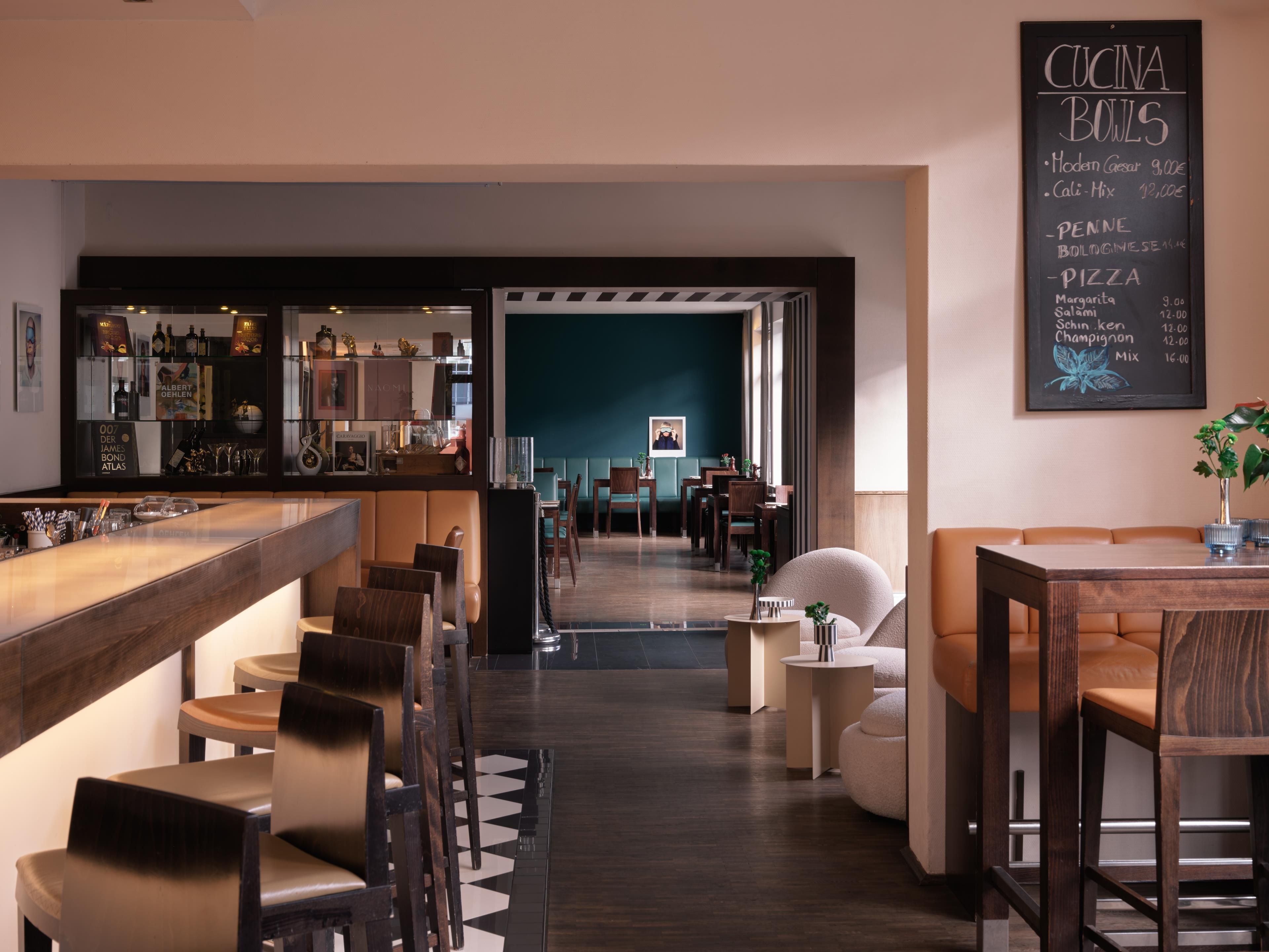 A restaurant interior with a bar area, seating, and a chalkboard menu.