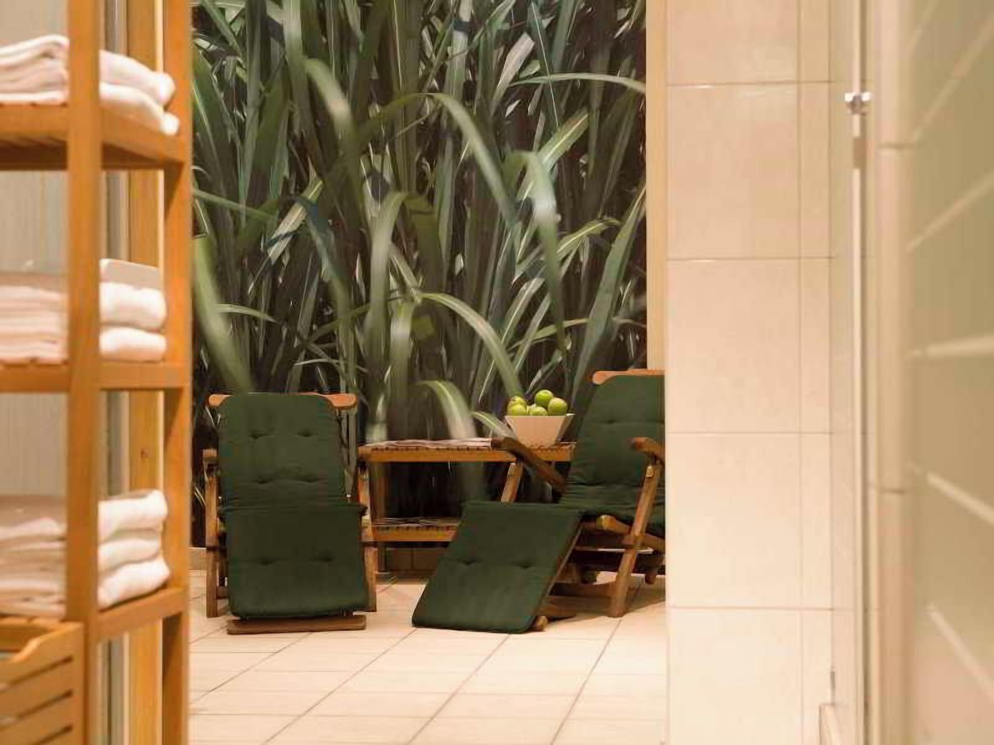 A room with a wooden chair, a small table, and a plant.