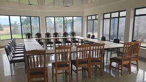 A conference room with a long table and chairs, large windows, and a tiled floor. - Vijiji Hotel and Conference Eldoret (Eldoret)