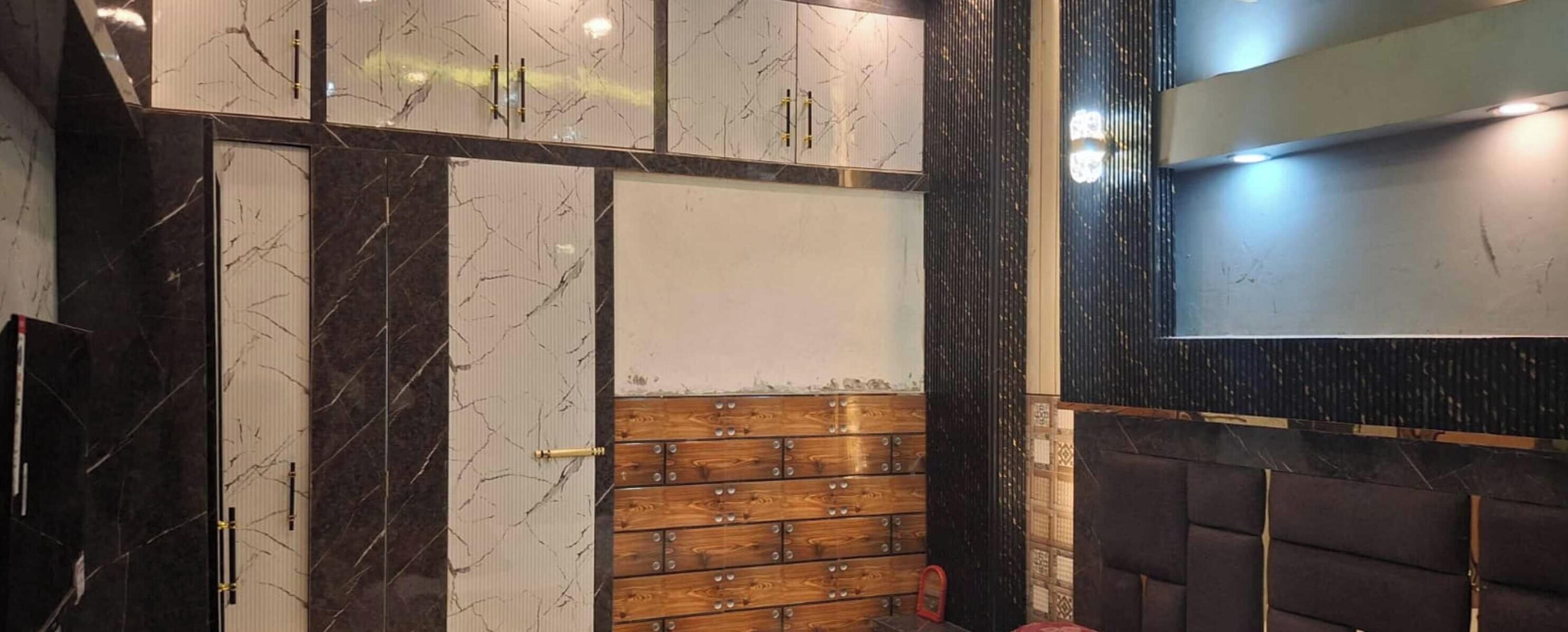 A room with a marble wall, wooden panel wall, and a large mirror.