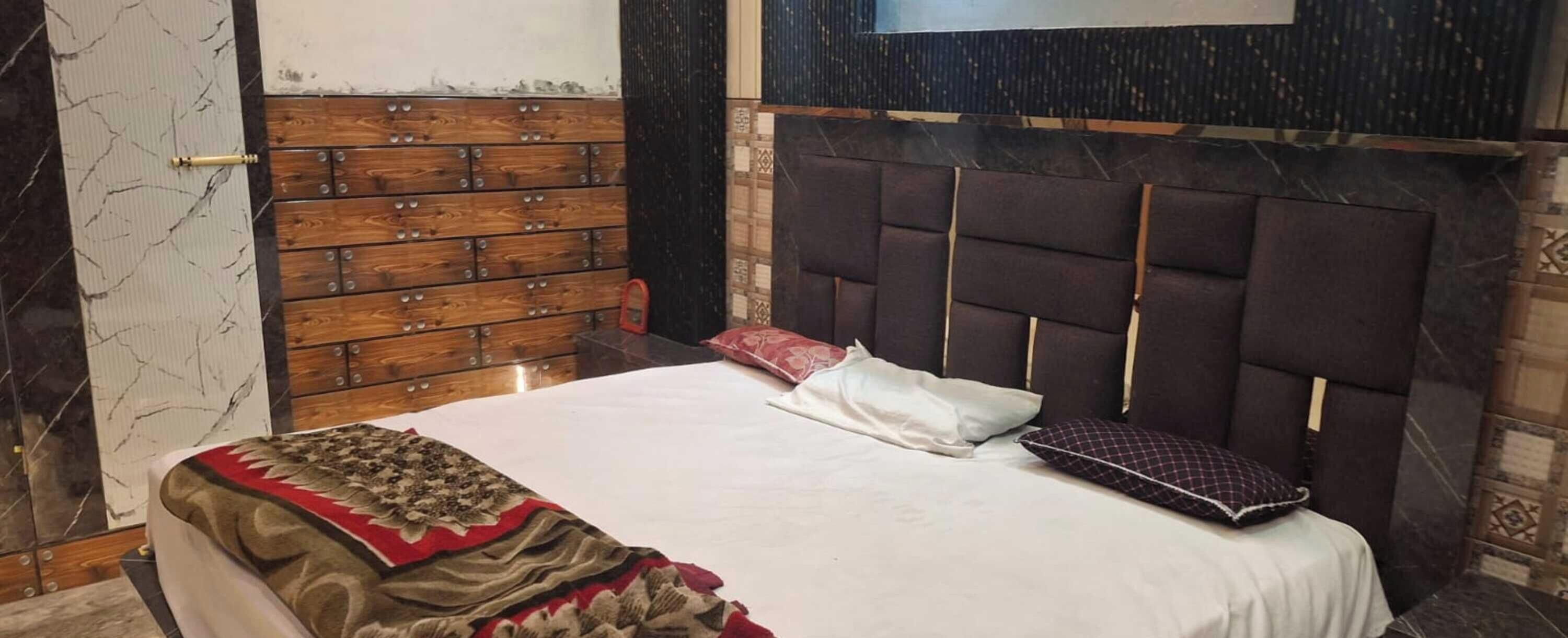 Une chambre à coucher avec un lit, une commode en bois et une tête de lit.