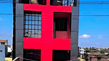 Ein mehrgeschossiges Gebäude mit einem auffälligen roten Kreuz-Design an der Fassade.