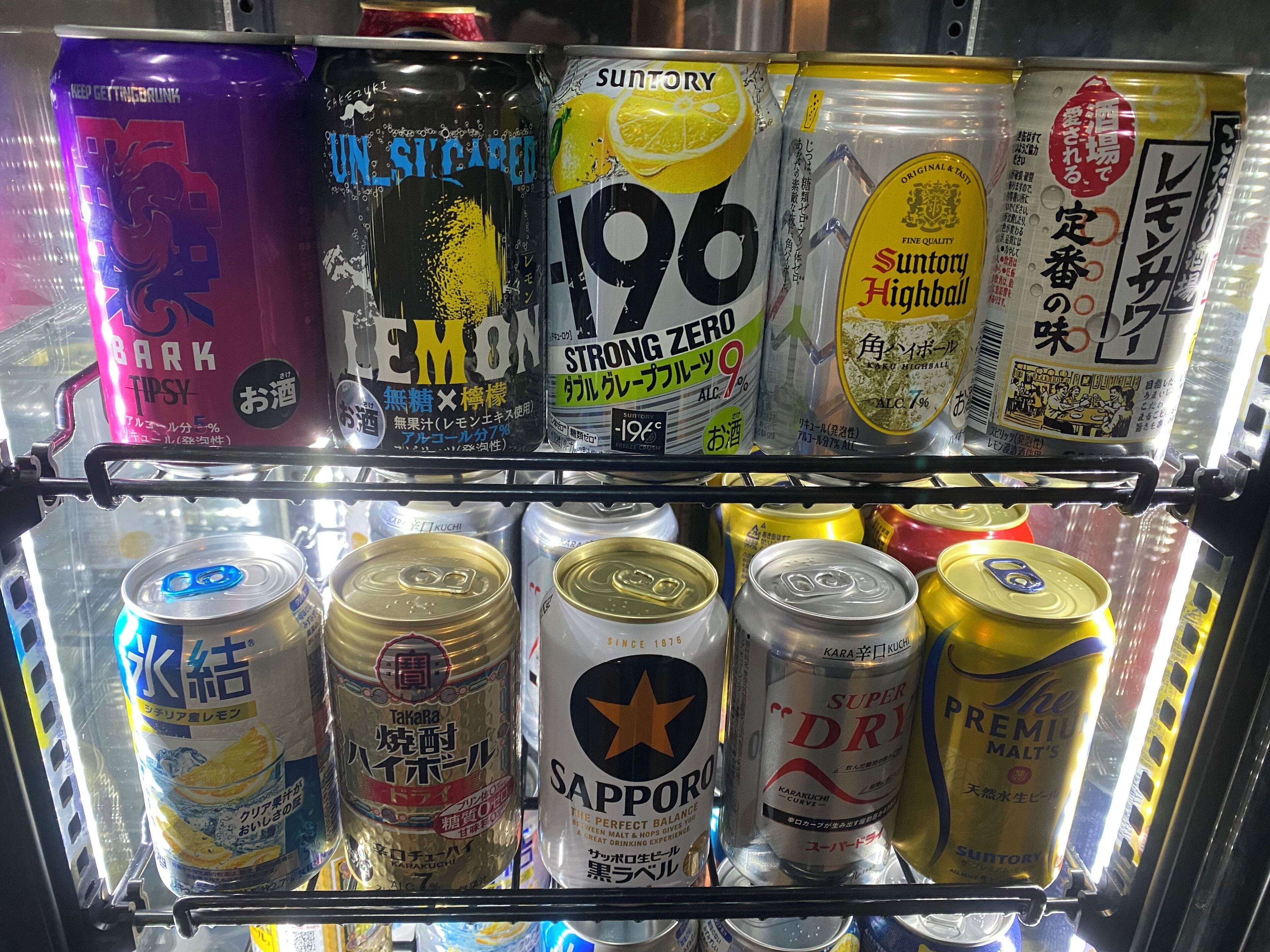 Mostrador refrigerado con diversas bebidas enlatadas.