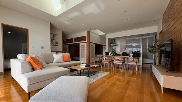 A spacious living area with a sofa, ottoman, and dining table. - BAY LUNA (Hakodate)