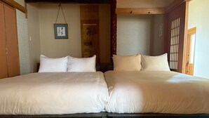 A traditional Japanese-style room with two beds, tatami flooring, and shoji screens. - BAY LUNA  (Hakodate)