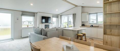 Un interior moderno de autocaravana con comedor, cocina y sala de estar.