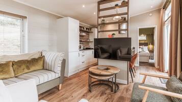 A modern living room with a sofa, a coffee table, and a TV.