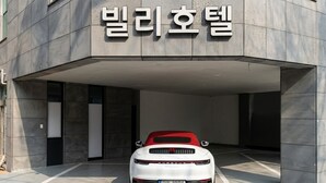 Une Porsche blanche était garée dans le garage d’un immeuble moderne.