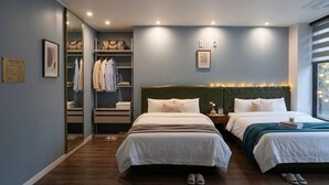 Une chambre avec deux lits, un dressing et une fenêtre donnant sur un beau paysage.