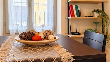 Une table à manger agrémentée d’un chemin de table décoratif, une assiette de fruits et une chaise.