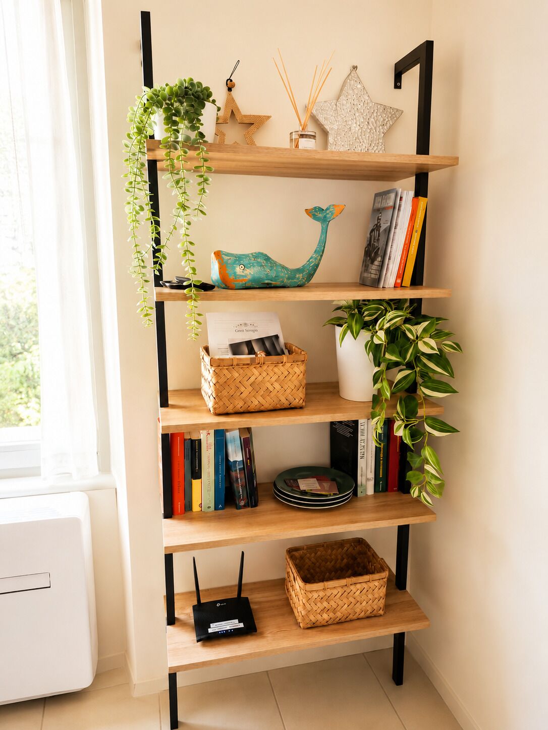 En reol med pynteting, bøger og en lille plante.