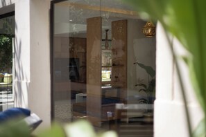 Ein modernes Interieur mit Glastrennwand, Holzschrank und Pendelleuchte.