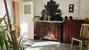 A room with a wooden cabinet, a chair, and a door.