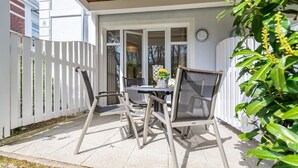 A patio with a table and chairs, a wooden ceiling, and a white fence. - Binz - WE Prorer Wiek 1 - Apartment for 4 persons near the beach and the center (Binz)