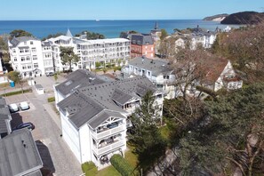 Un hotel frente al mar con varias edificaciones, un estacionamiento y vistas al océano.