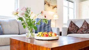 A living room with a wooden coffee table, a vase with flowers, and a fruit bowl. - Binz - WE Prorer Wiek 1 - Apartment for 4 persons near the beach and the center (Binz)