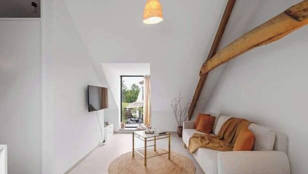 A modern living room with a sofa, a coffee table, and a TV mounted on the wall. - BARN - Waasmunster (Waasmunster)