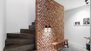 A staircase with a brick wall on one side and a wooden bench at the bottom. - BARN - Waasmunster (Waasmunster)