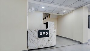 Een receptiebalie met een marmeren ontwerp en de letters 'OYO' erop.