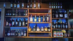 A bar with multiple shelves of liquor bottles and a few packaged drinks. - Asis Hotel Eldoret  (Eldoret)
