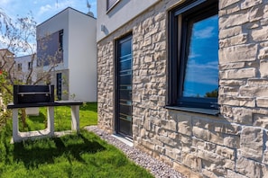 A modern building with a stone facade, large windows, and a small outdoor seating area. - Villa Petra with Pool and Sea View (Medulin)