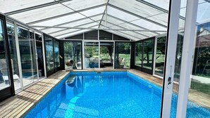 Une serre à structure transparente avec une piscine.