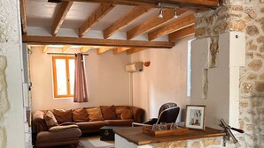 Une cuisine rustique avec des poutres apparentes, un mur en pierre et un sol en briques.