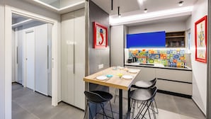 A modern kitchen with a dining table, chairs, and a colorful backsplash. - Pop House in the Heart of Sanita by Wonderful Italy (Naples)
