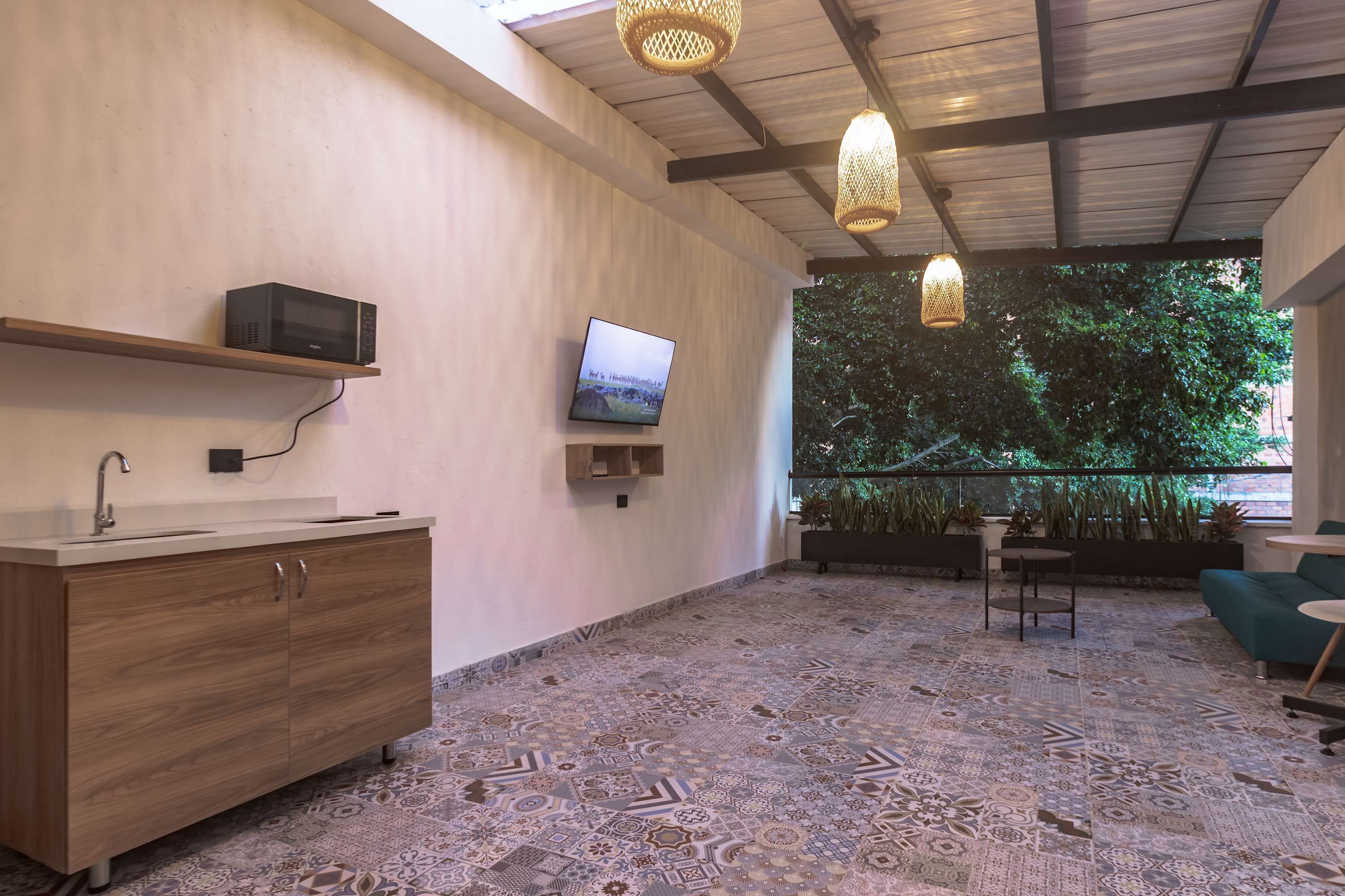 A modern bathroom with a wooden vanity, a microwave, and a television.