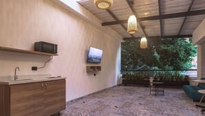 A modern bathroom with a wooden vanity, a microwave, and a television. - NOK Amazing Loft in Laureles (Medellín)