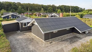 A residential area with modern houses featuring sloped roofs and a gravel driveway.