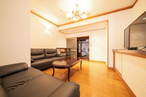 A living room with a sofa, a coffee table, and a wooden floor. - Sanada Maru (Kaizuka)