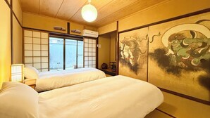 Una habitación tradicional japonesa con suelo de tatami, celosía de shoji y futón.