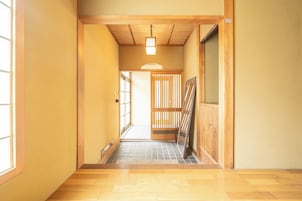A narrow hallway with wooden flooring, a sliding door, and a light fixture.