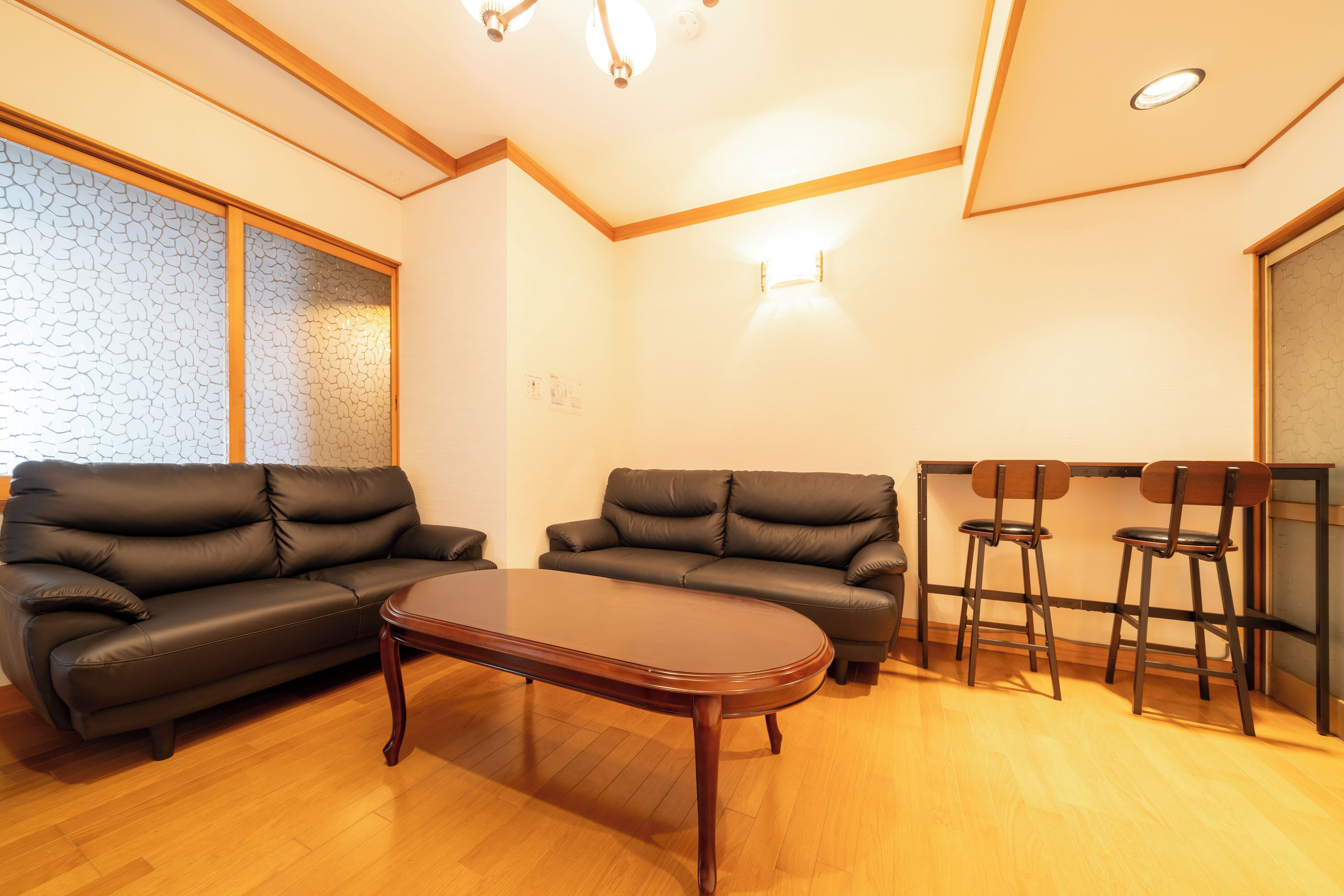 A living room with two sofas, a coffee table, and a bar area with stools.