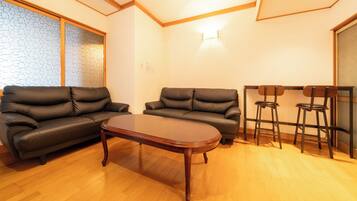 A living room with two sofas, a coffee table, and a bar area with stools.