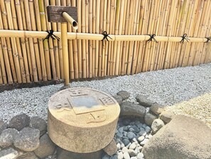 A bamboo fence, a stone well, and a pipe system.