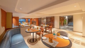 Un hall d’hôtel moderne avec un espace salon, un bar et une vue sur la rue.