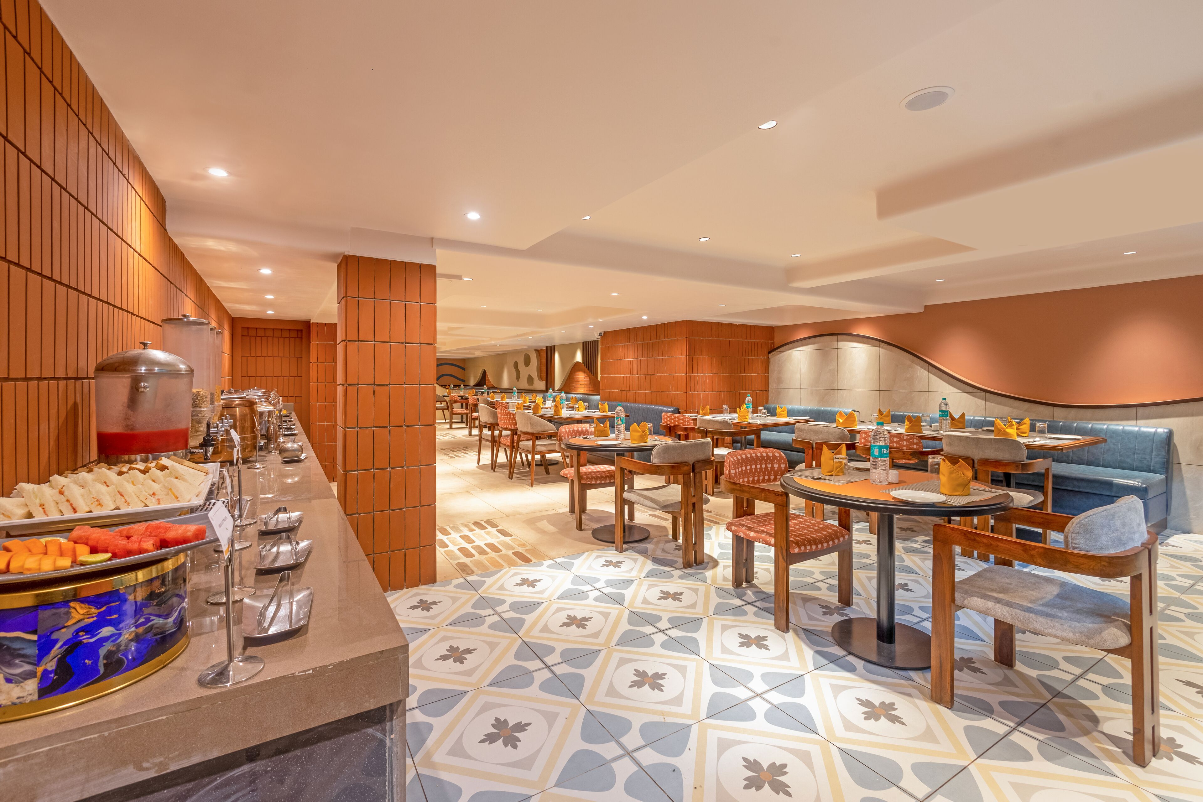 A hotel lobby with a buffet, seating areas, and a patterned floor.