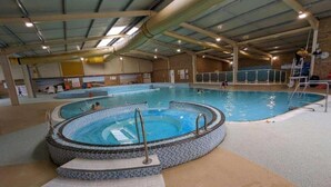 Une piscine intérieure dotée d’un jacuzzi et de marches permettant d’y accéder.