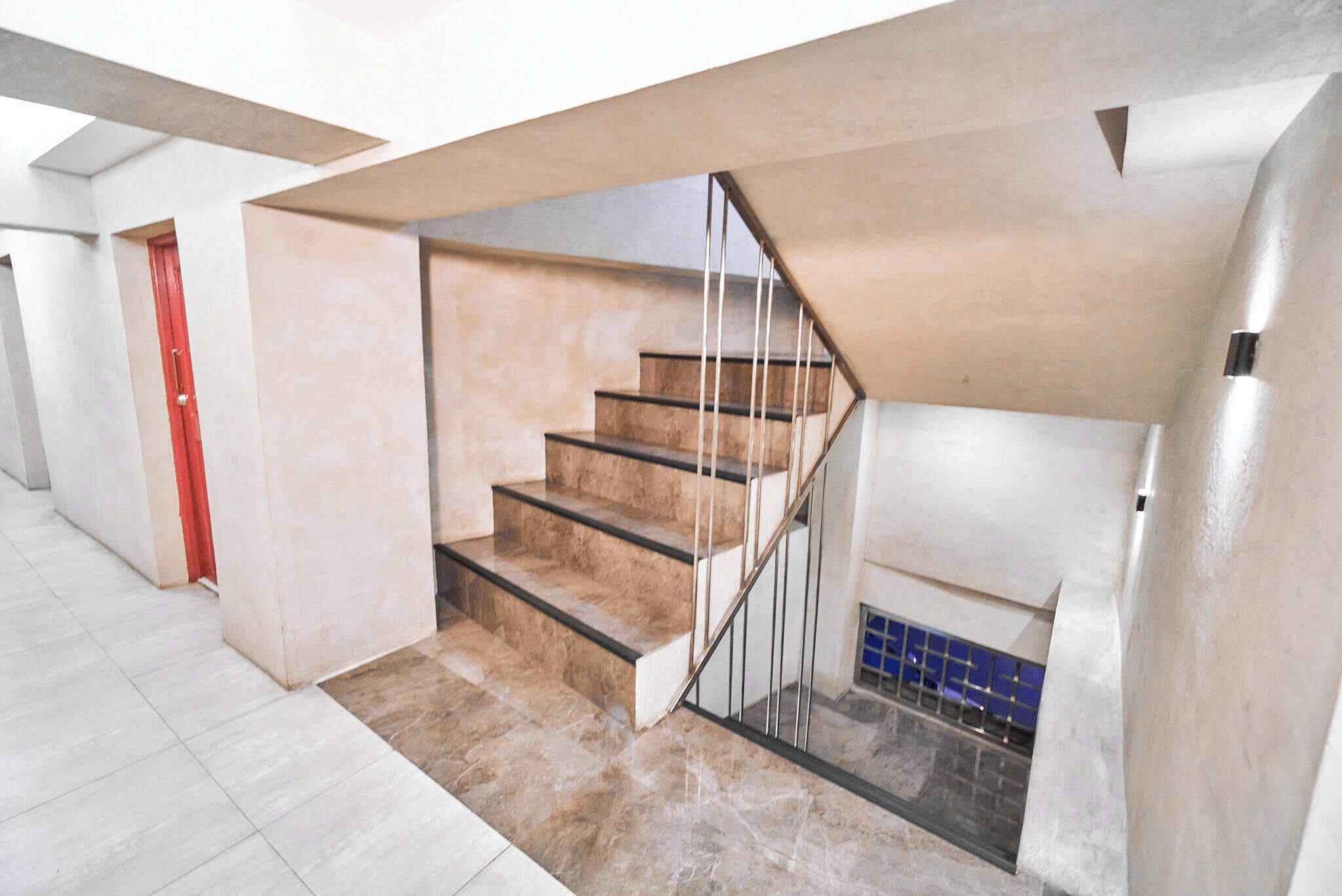 A modern staircase with a glass railing, leading to a lower level.