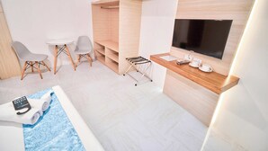 A modern hotel room with a TV, seating area, and a small pool. - Circuit Hostel Makati (Makati)