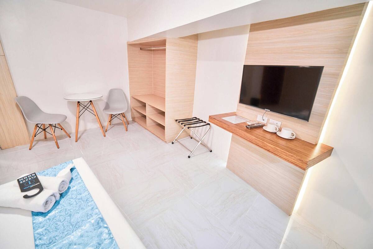 Ein modernes Hotelzimmer mit Fernseher, einer Sitzecke und einem kleinen Pool.