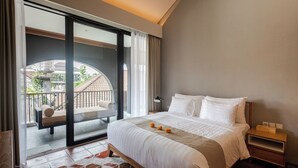 Ein Hotelzimmer mit einem großen Bett, einem Nachttisch, einer Schiebetür zum Balkon und Blick ins Freie.