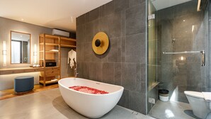 Ein modernes Badezimmer mit freistehender Badewanne, einer gläsernen Duschkabine und einem Waschtisch mit Spiegel.